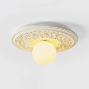 Contemporary flush-mount ceiling light with embossed resin base and warm glowing spherical shade