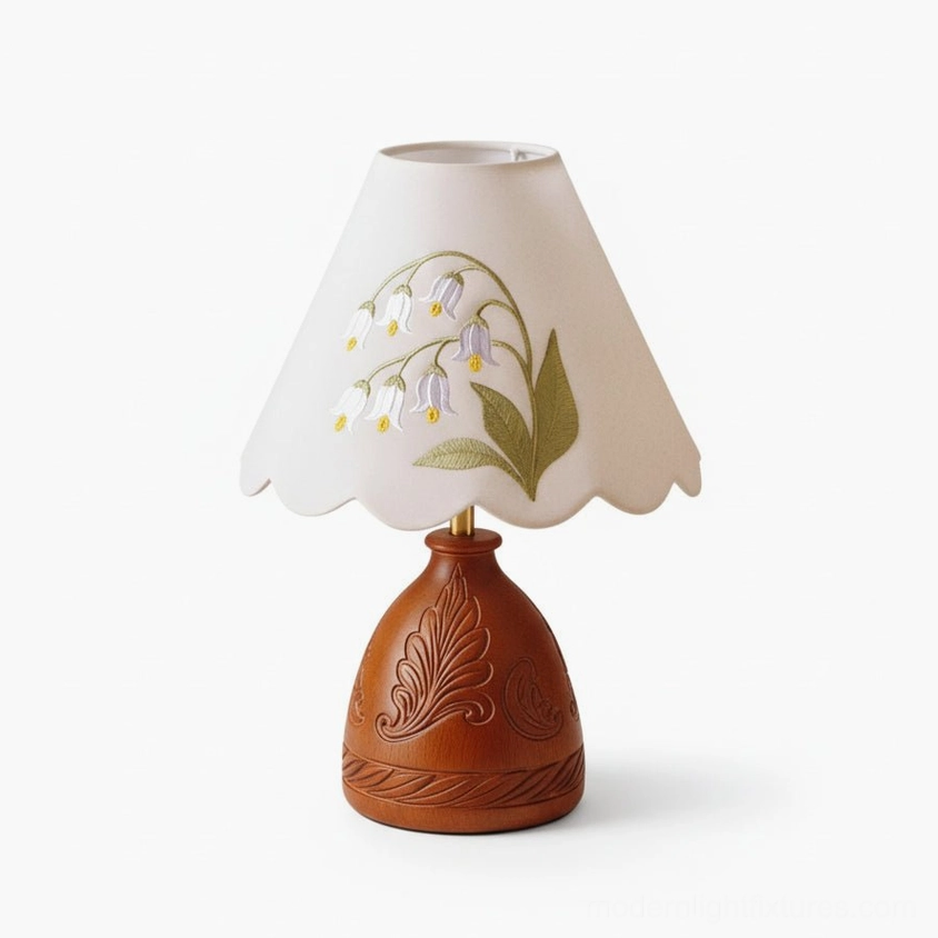 Studio front view of embroidered lily table lamp against neutral white background