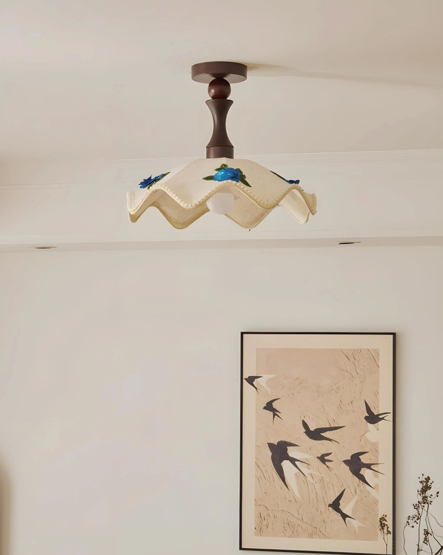 Scalloped floral ceiling lamp mounted on residential interior wall with matching botanical swallows art print decor