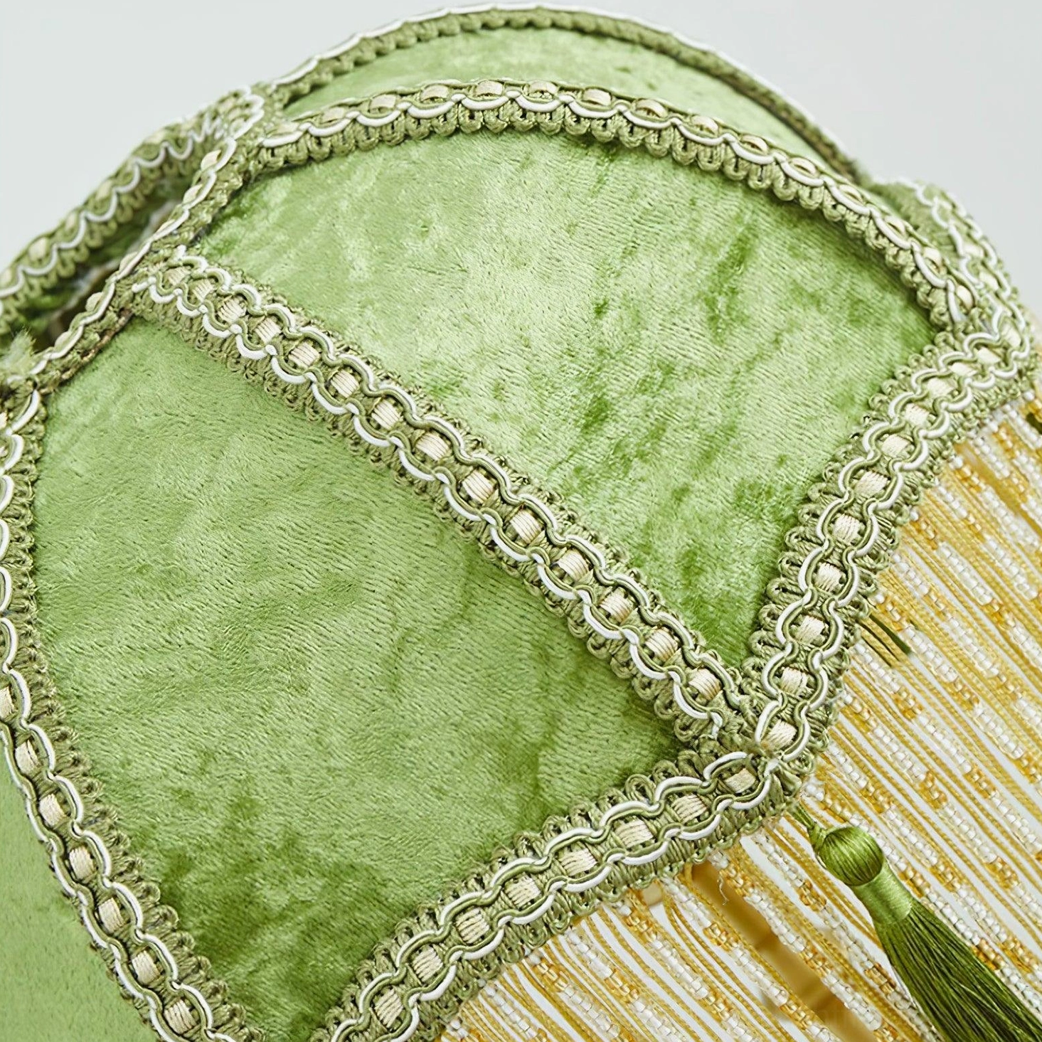 Emerald green table lamp with tassel accents displayed in home interior design styling context