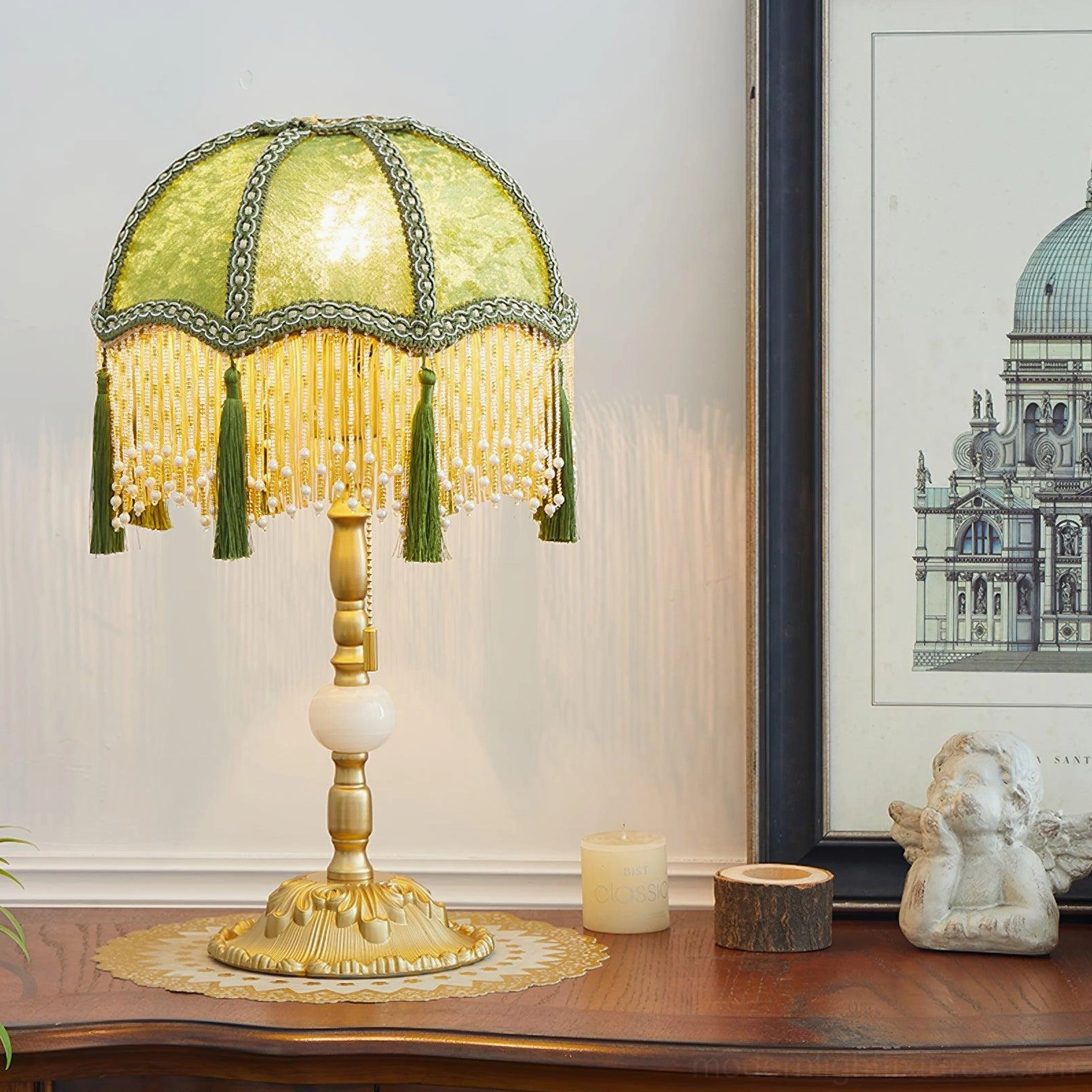 Lit emerald green vintage table lamp on wooden console table with home decor accessories and carved gold base