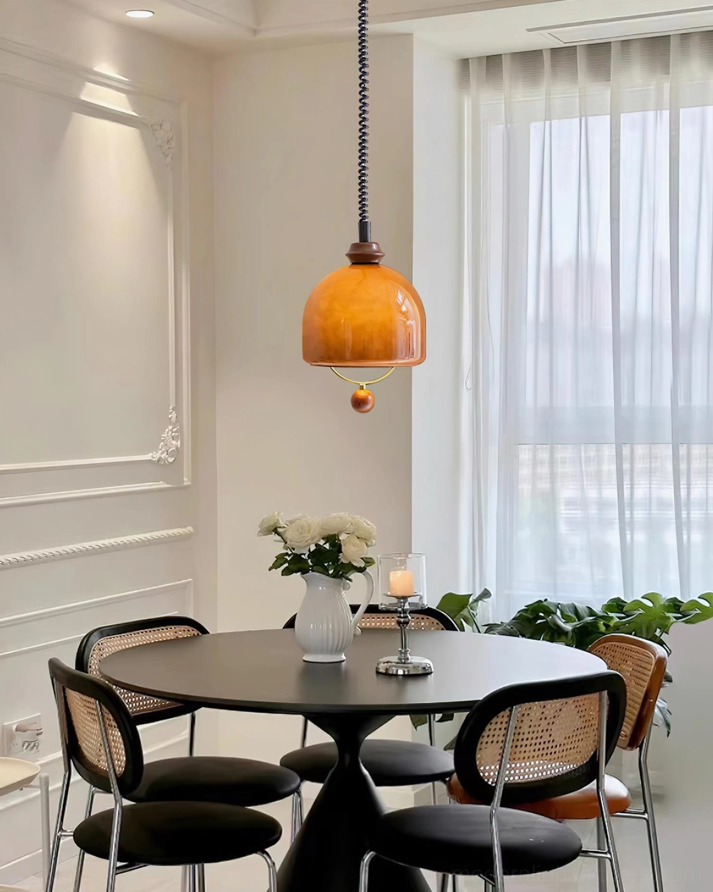 Single Enda amber glass dome pendant light illuminating French-style round dining space with warm lighting