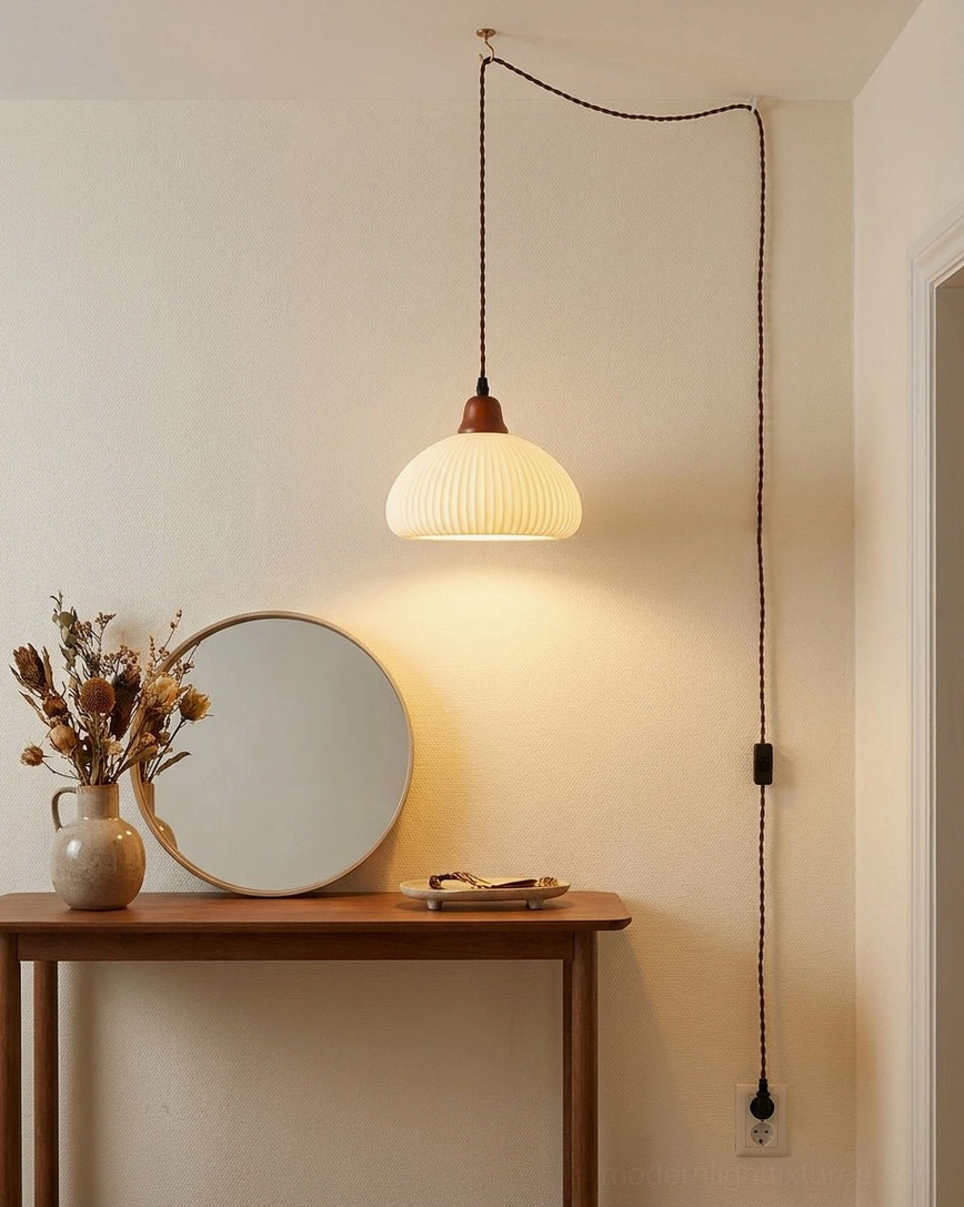 Dome-shaped ceramic plug-in pendant above console table with dried flowers and round mirror in hallway