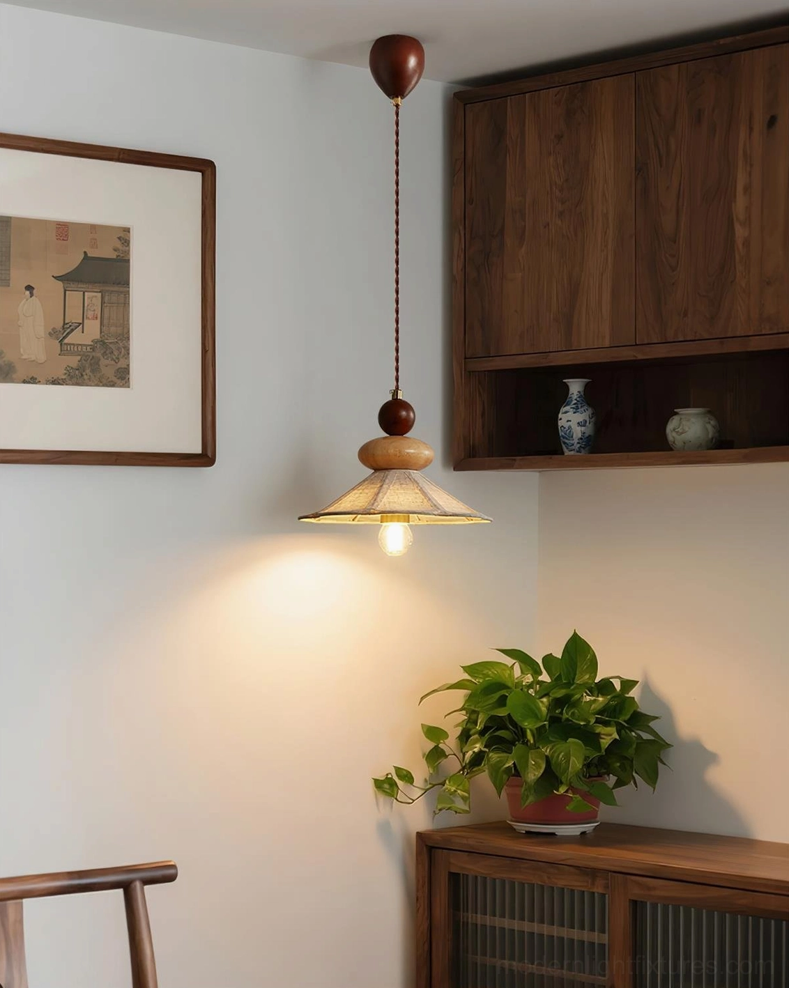 Pair of wooden pendant lamps in entryway above walnut cabinet with traditional wall art, warm cozy home lighting