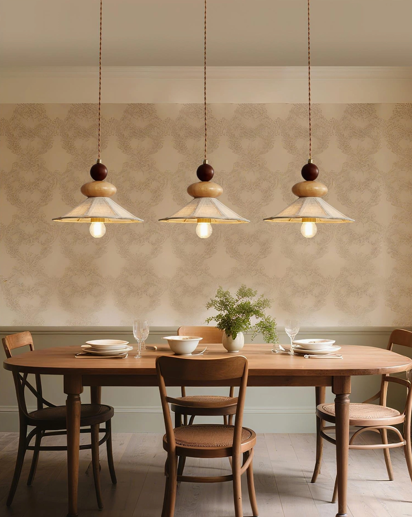 Set of three wooden pendant lights over long formal dining table, neutral natural rustic elegant dining space lighting