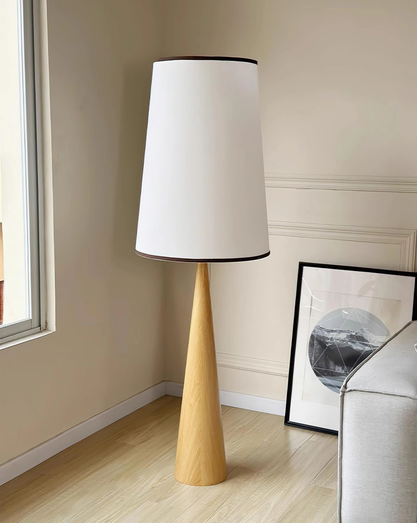 Minimalist floor lamp in natural oak wood finish showcasing tapered base design detail