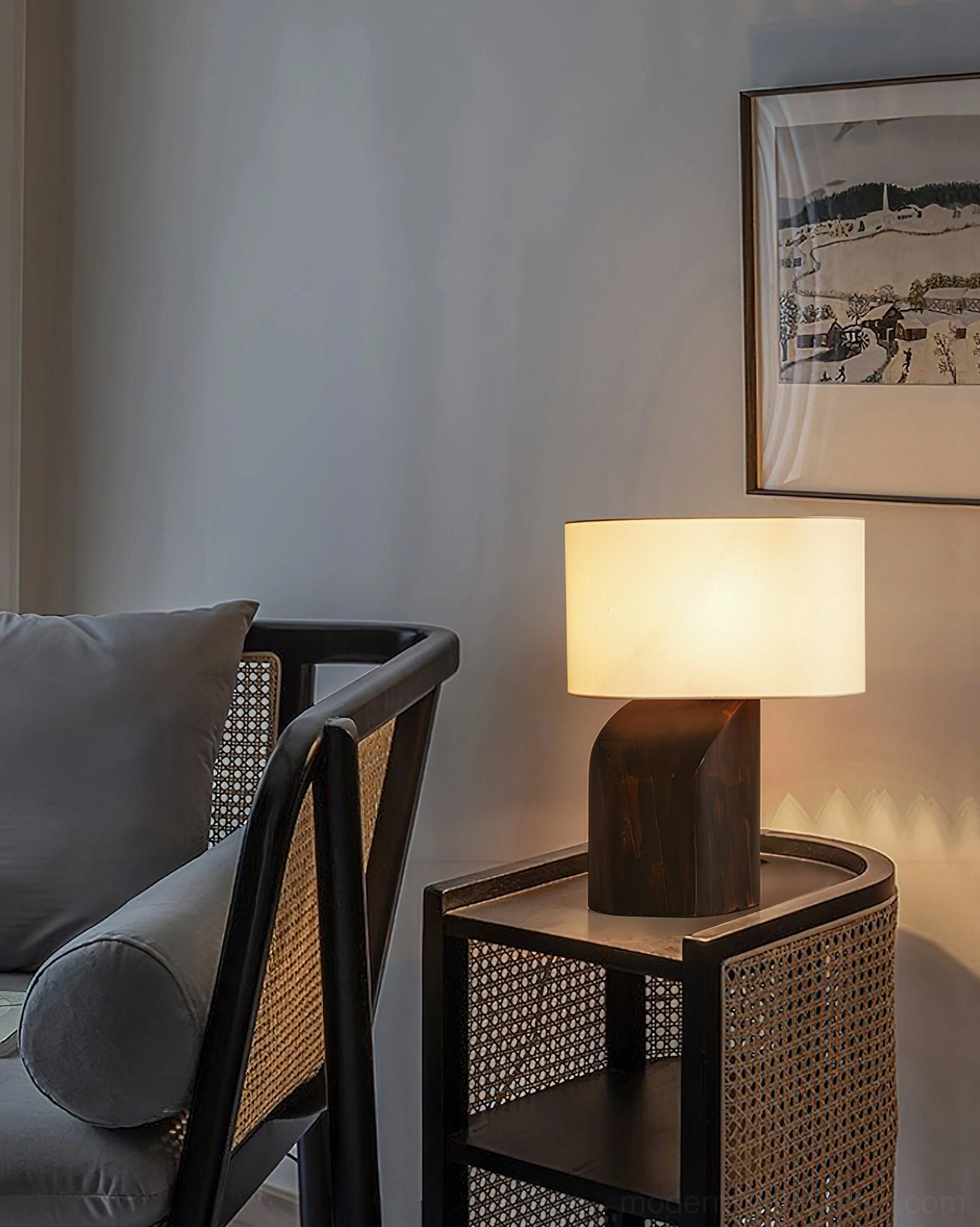 Sculptural wood table lamp in cozy lounge corner with armchair, warm ambient lighting in sitting area