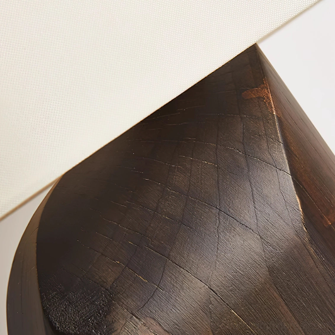 Close-up of Esla dark wood lamp base showing natural grain pattern, carved sculptural wood details