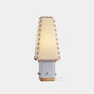 Estela handcrafted table lamp front view showing tapered fabric shade with contrast stitching and geometric metal base with wood accents