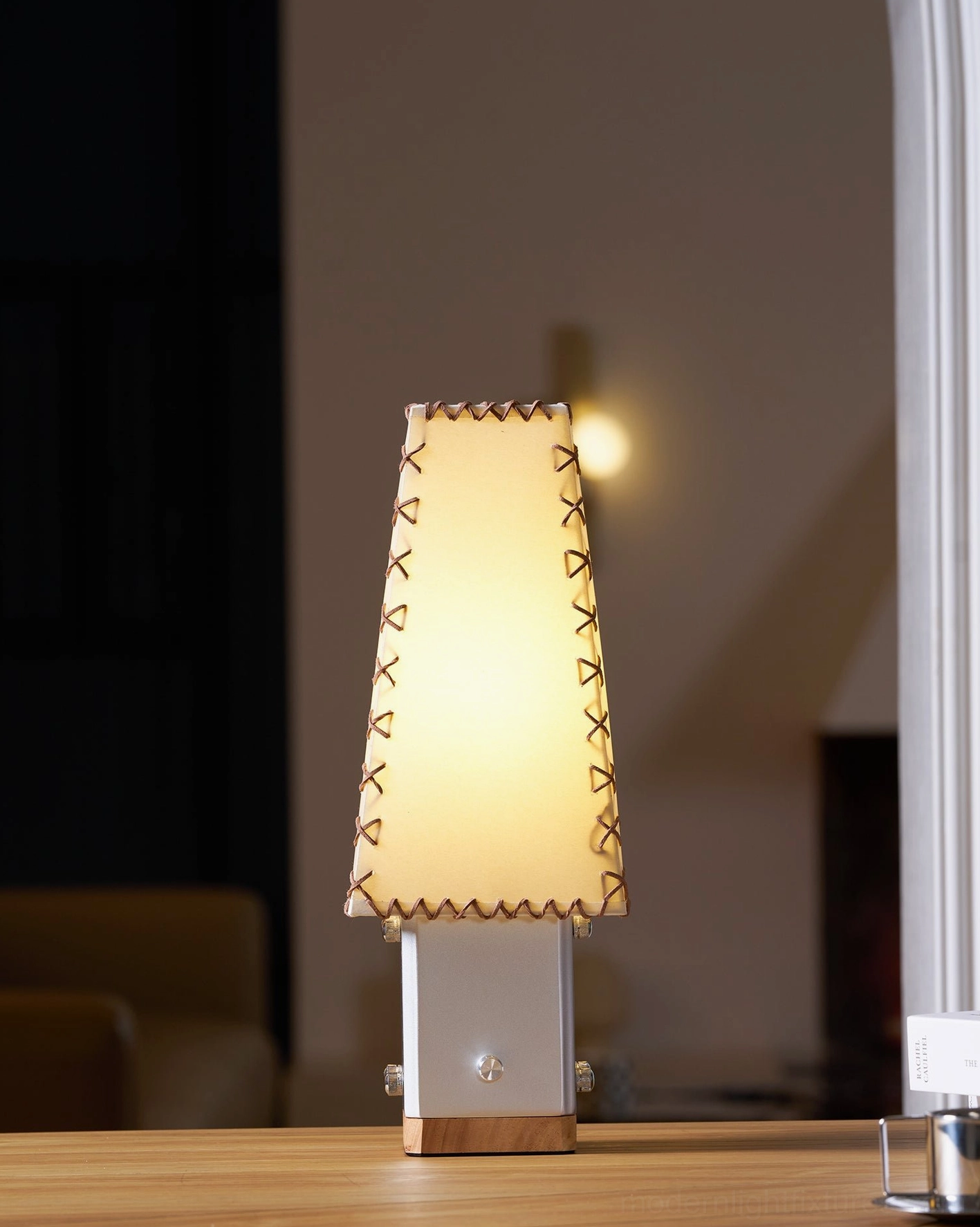 Estela table lamp three-quarter view displaying tapered shade silhouette and metal wood construction