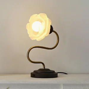 Gold and white Everbud table lamp with warm ambient lighting, aged brass finish and matte black base