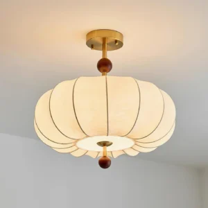 Ribbed fabric ceiling light fixture with warm glow, brass mounting and wood bead details - low angle perspective