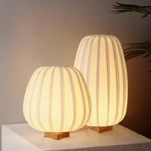 Pair of fabric minimalist table lamps with warm ambient lighting on natural wooden base