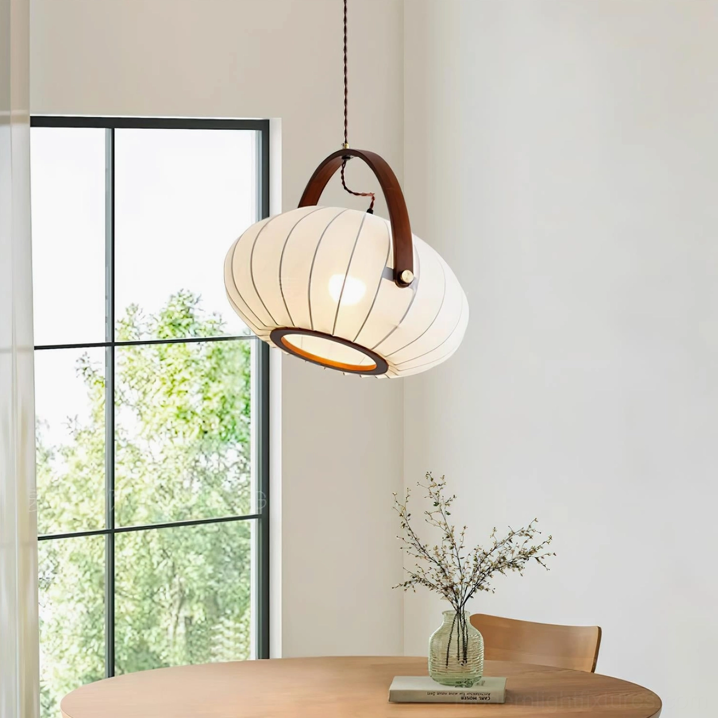 Modern pendant lamp hanging above wooden dining table in minimalist dining room with natural window light