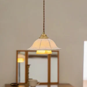 Fabric pendant lamp in vanity area with tri-fold mirror, showing warm ambient glow and twisted brown cord