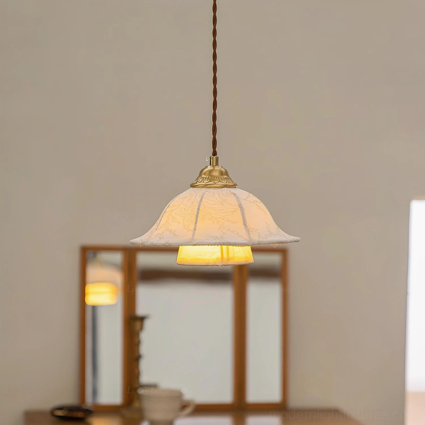 Fabric pendant lamp in vanity area with tri-fold mirror, showing warm ambient glow and twisted brown cord