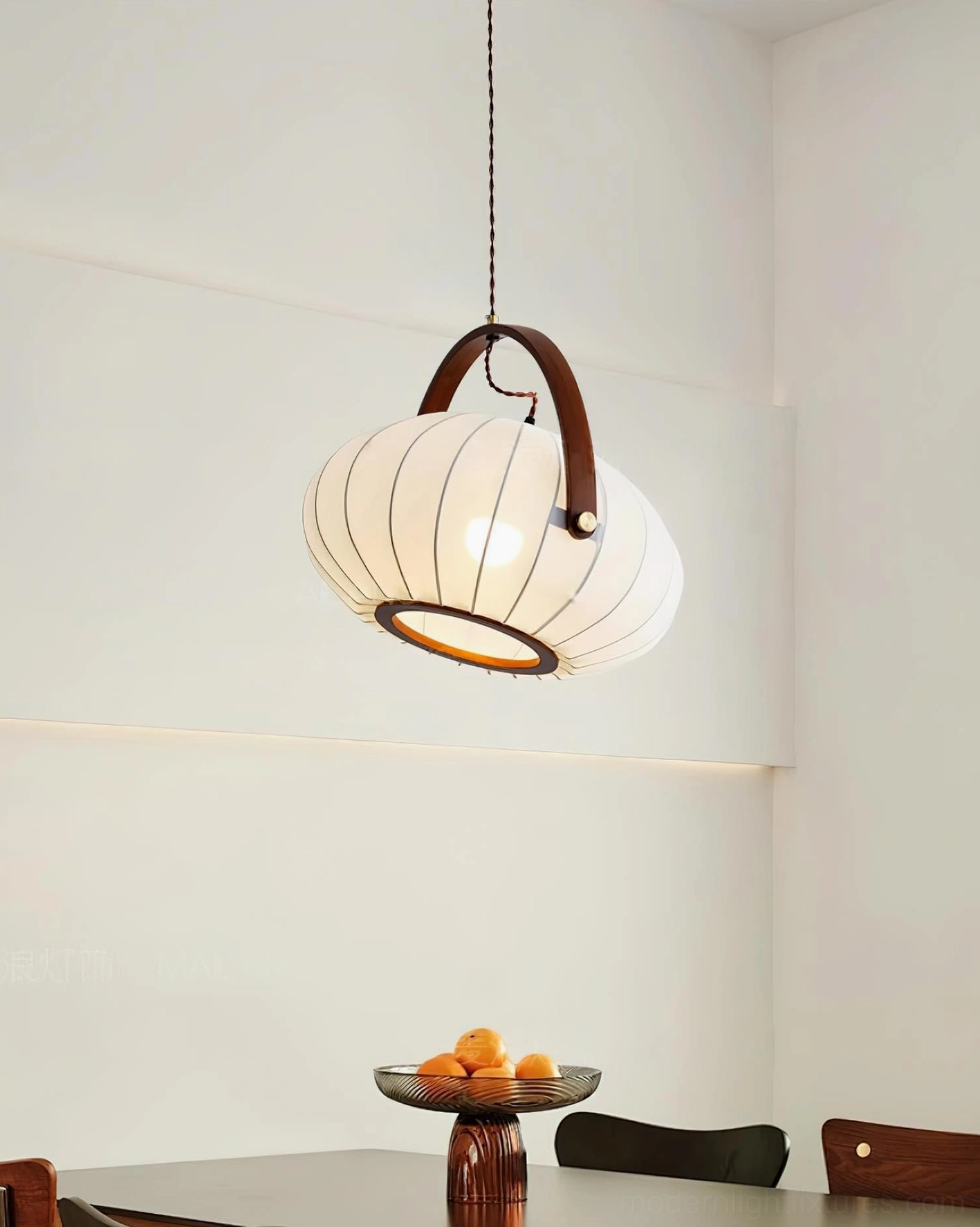 Warm glowing fabric pendant lamp above casual dining area with ambient lighting and table décor