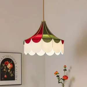 Tri-color scalloped fabric pendant light hanging in interior space with warm glow and floral wall art
