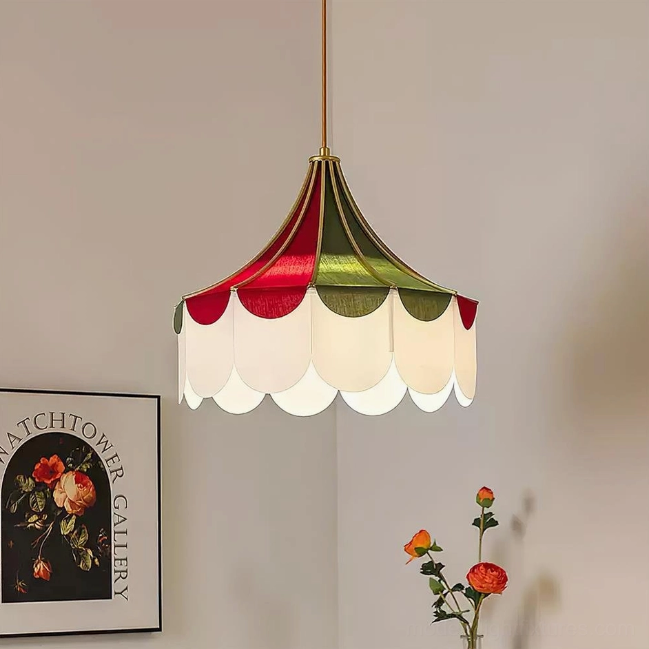 Tri-color scalloped fabric pendant light hanging in interior space with warm glow and floral wall art