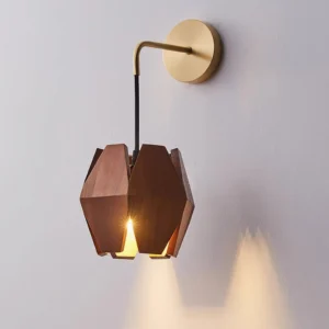 Modern faceted wood wall sconce casting directional light downward on gray wall backdrop