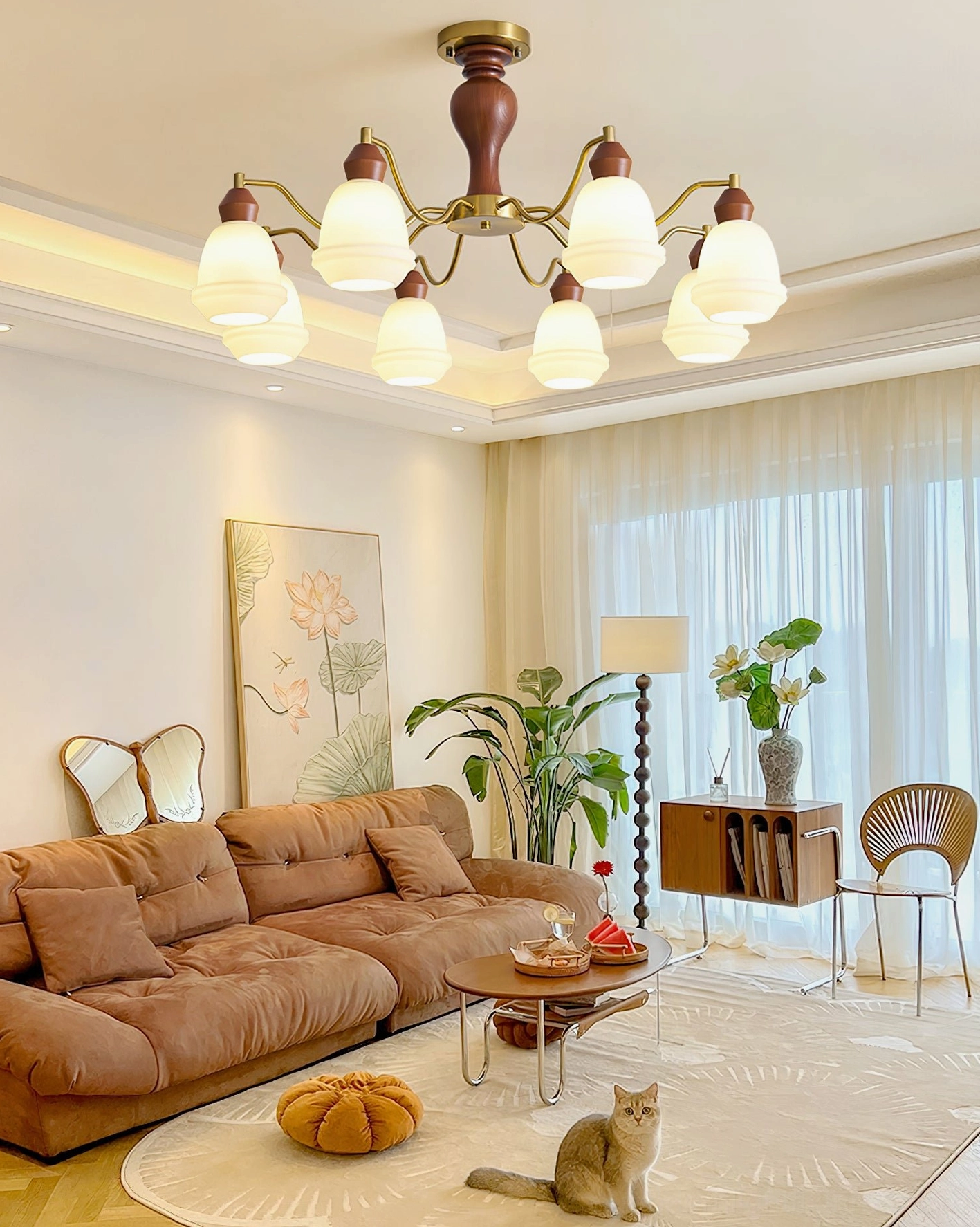 Modern wood and brass chandelier installed in warm farmhouse living room with leather sofa