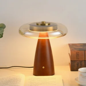 Fathom table lamp styled in home office setting with books and warm ambient lighting from cognac glass shade