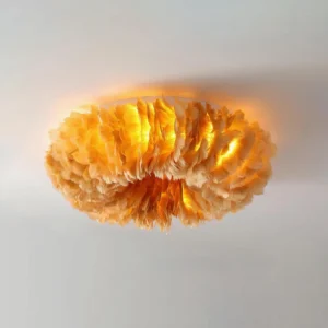 Overhead view of amber feather ceiling light fixture installed in modern white wall space with warm ambient illumination
