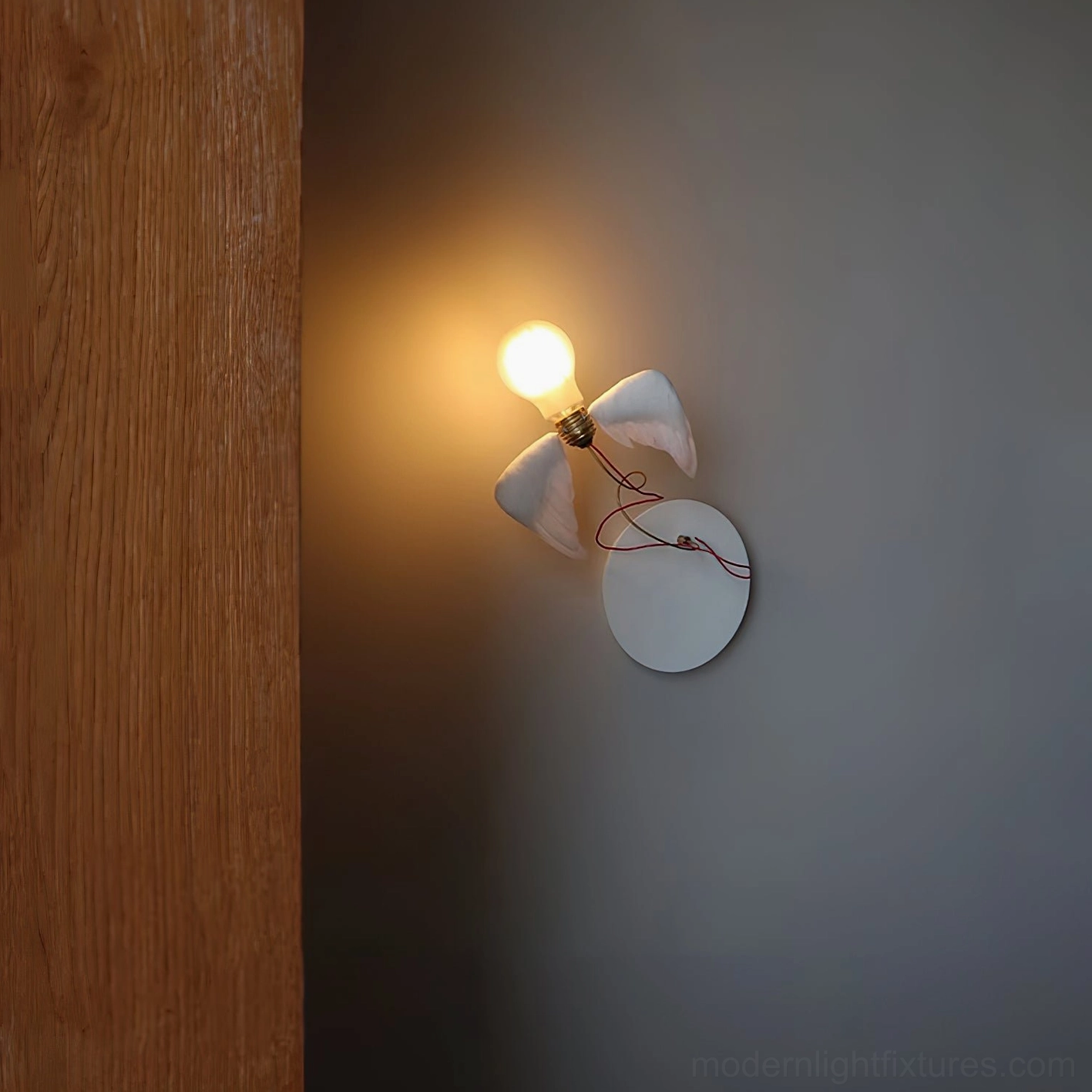 Feathered wall sconce in bathroom corner with glowing warm light, side view of mounted fixture on gray wall