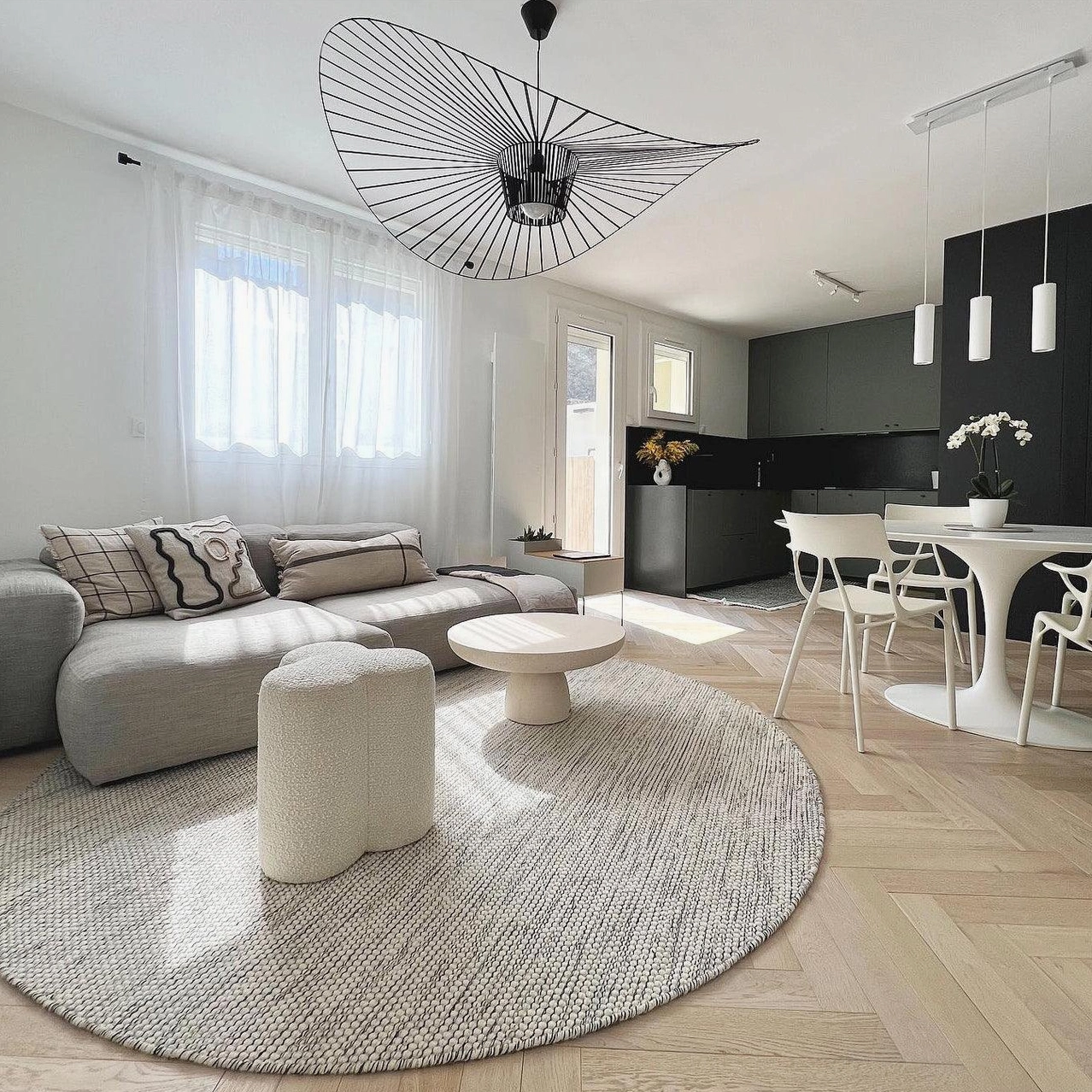 Woven fiber glass pendant lamp centered above dining table creating overhead focal point