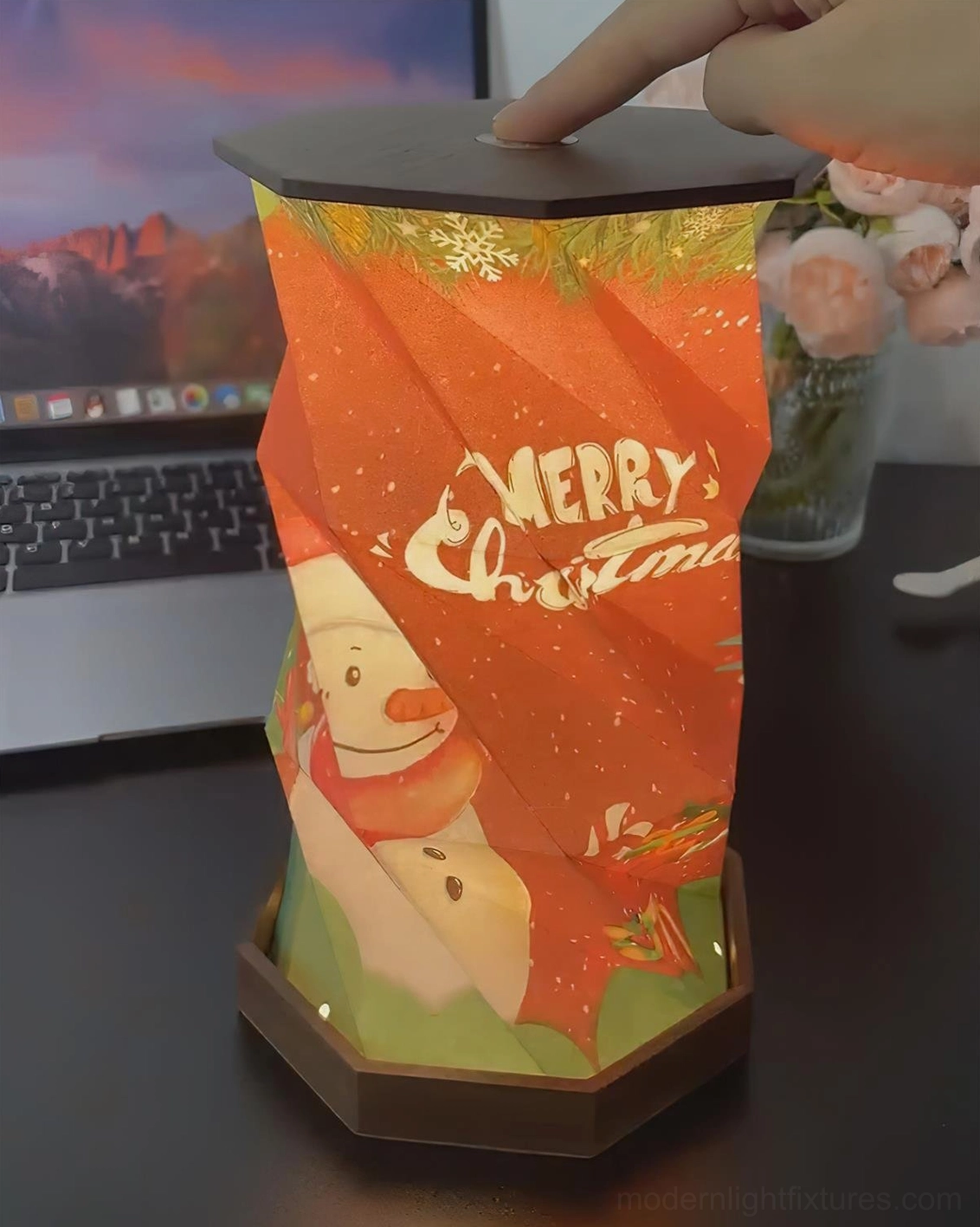 Fida Fold Paper Christmas Table Lamp with festive snowman print showing touch control panel on top and dark wood base in home office setup