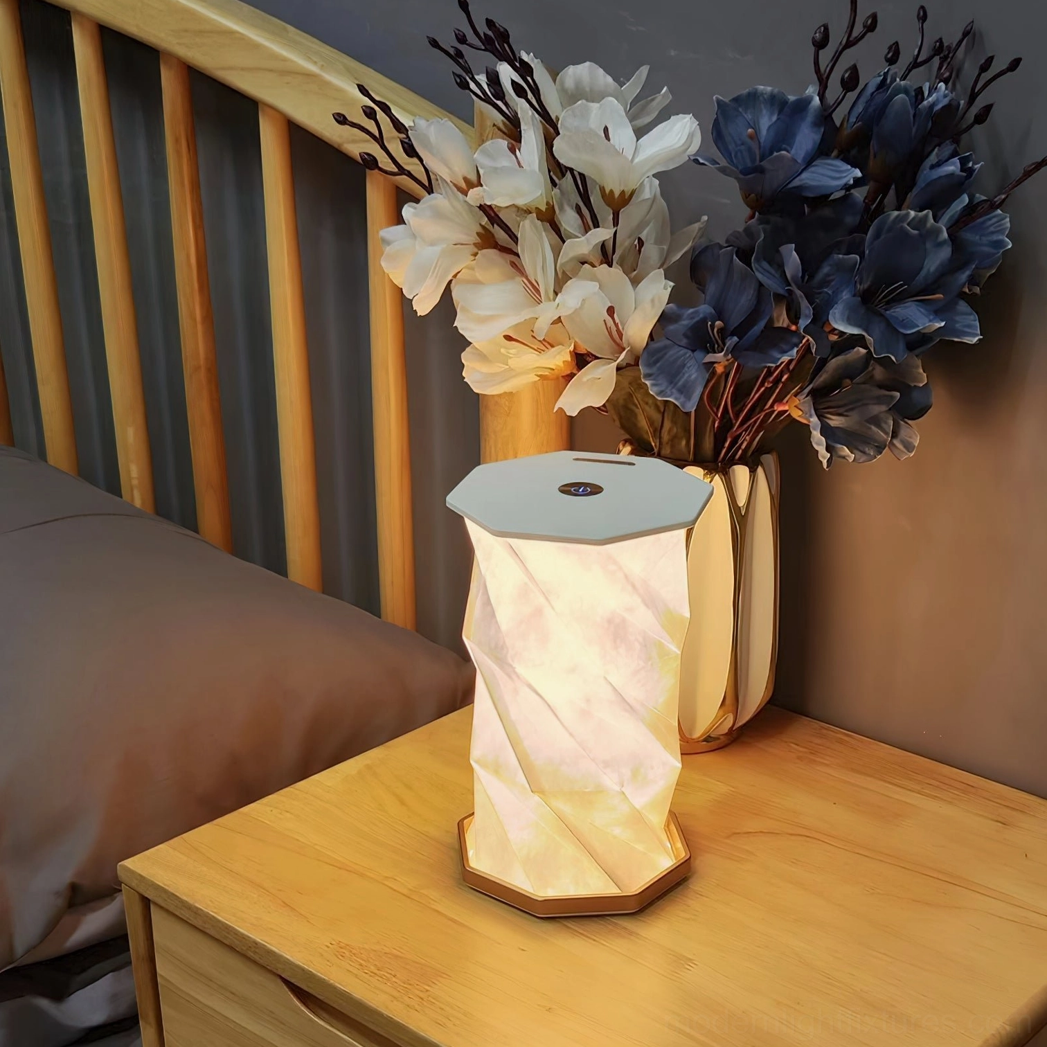 Modern fold table lamp displayed on bedroom nightstand with twisted paper shade and light wood base creating warm ambient lighting