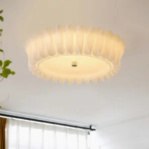 Modern ruffled ceiling lamp installed in minimalist living room, low-angle perspective showing fabric-like textured frame