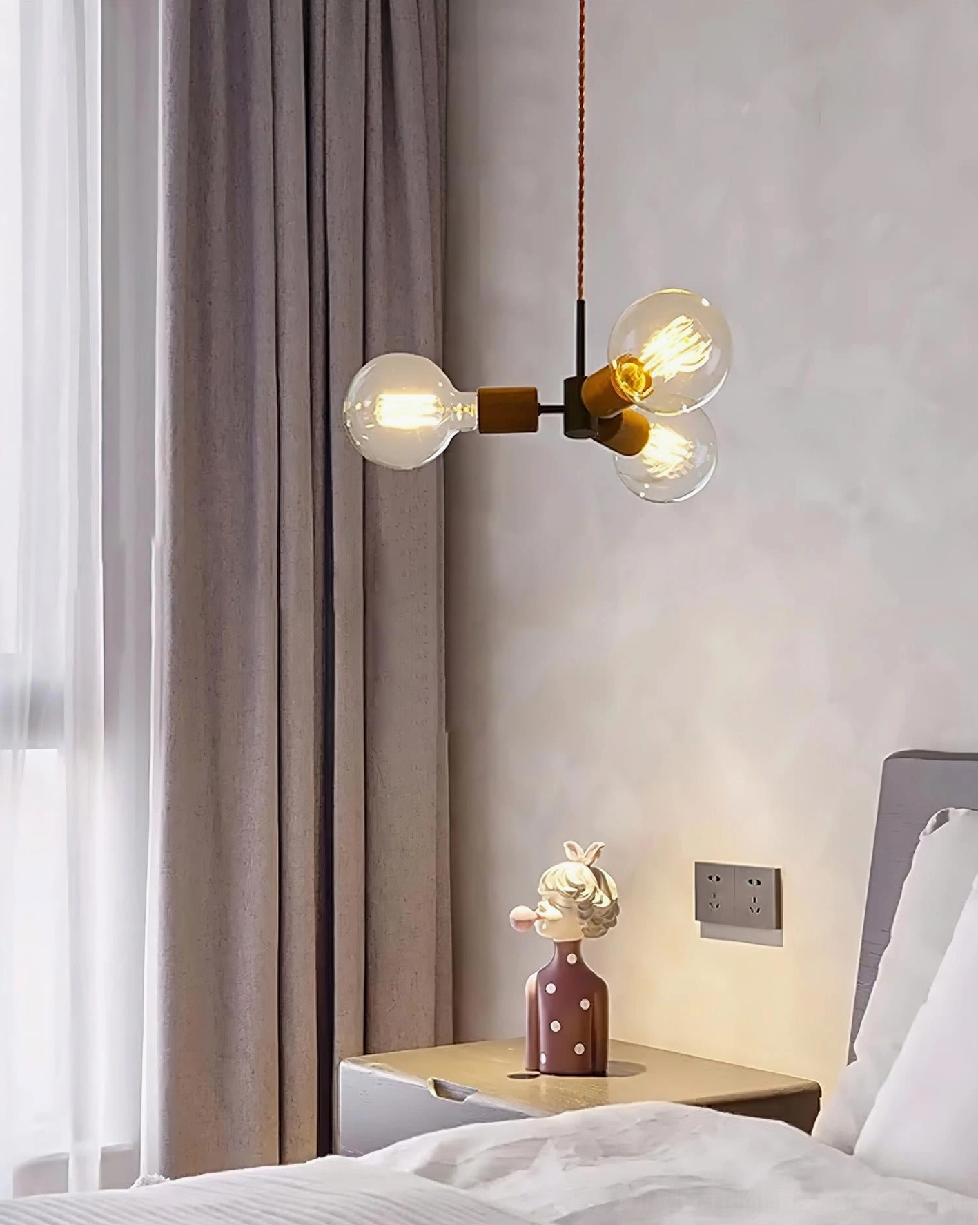 Filotto pendant light with warm Edison bulbs creating intimate lighting in modern bedroom with nightstand