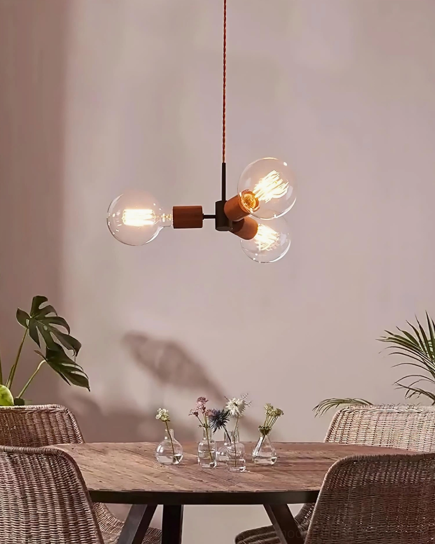 Filotto 3-head Edison bulb pendant creating warm glow in dining corner with botanical floral decor