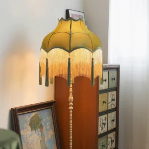 Lit Fina Tassel Floor Lamp casting warm glow in vintage home interior with wooden dresser
