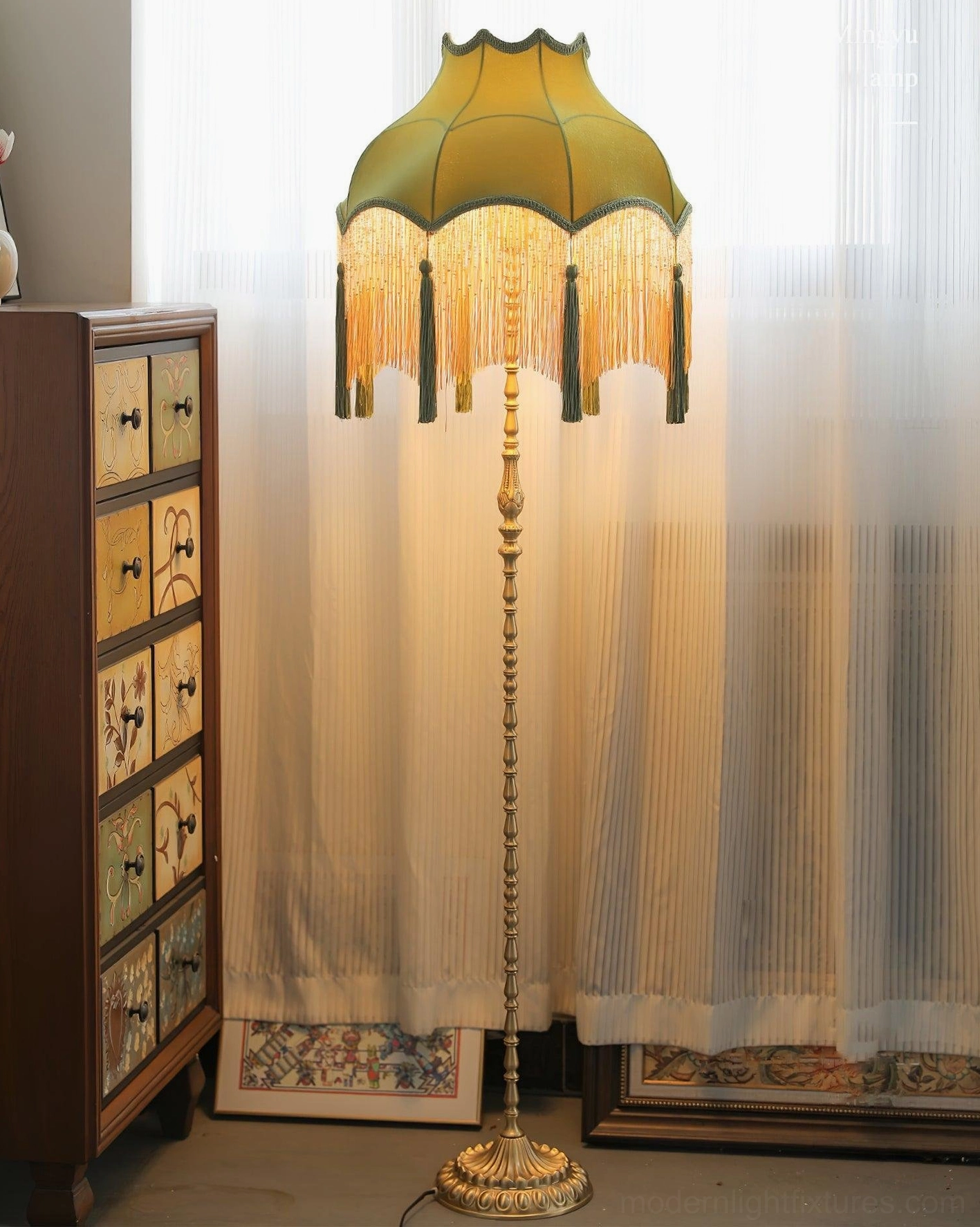Fina Tassel Floor Lamp in sunlit living room with sheer curtains and wooden cabinet