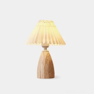 Fina travertine table lamp with pleated linen shade on white background, showing natural stone texture and off-white fabric shade