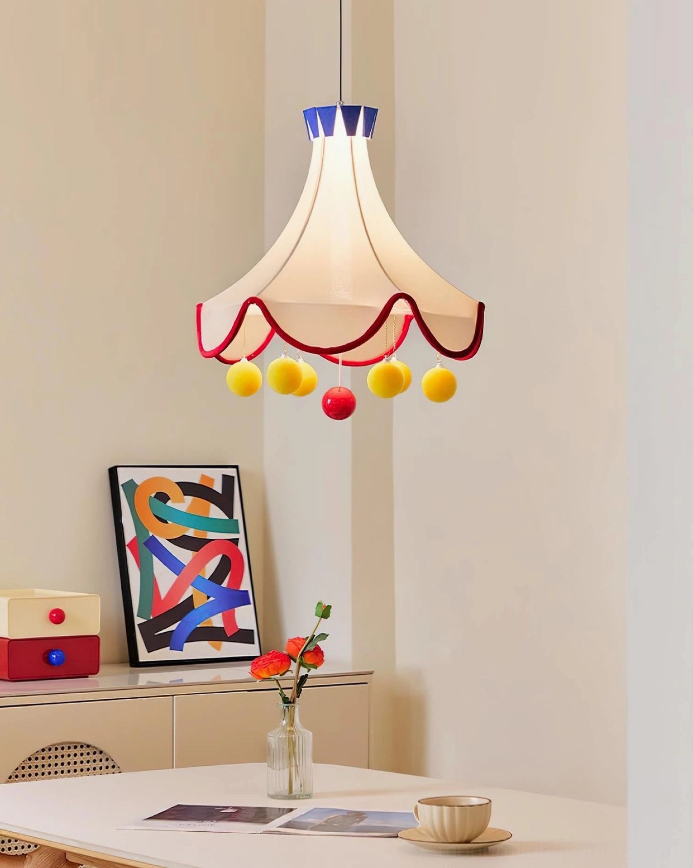 Finaflor playful pendant light installed above dining table in dining room space showcasing full set of decorative pom-pom accents and warm illumination