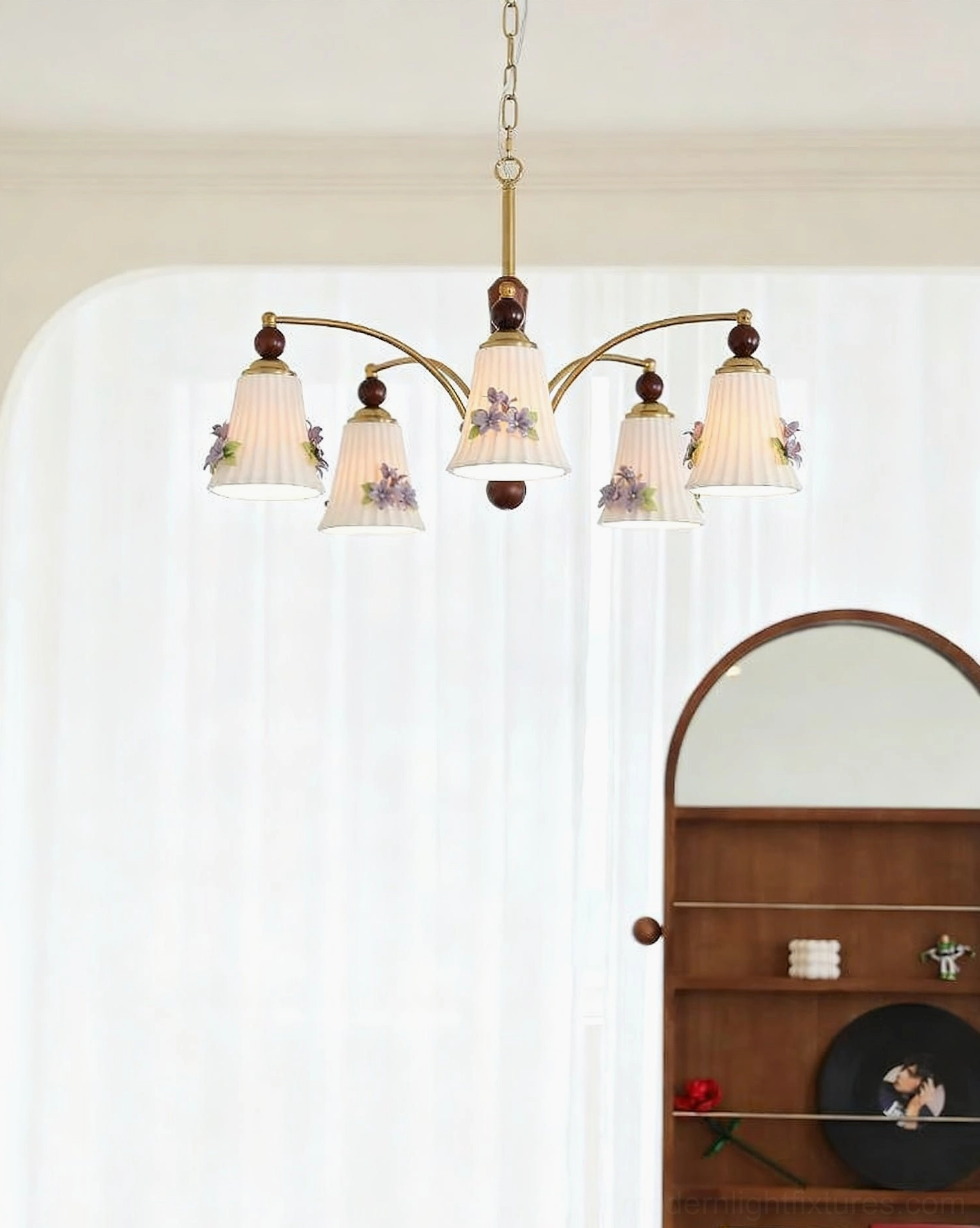 Low-angle view of Fiorenta chandelier with warm brass and wood tone floral shades against sheer curtains
