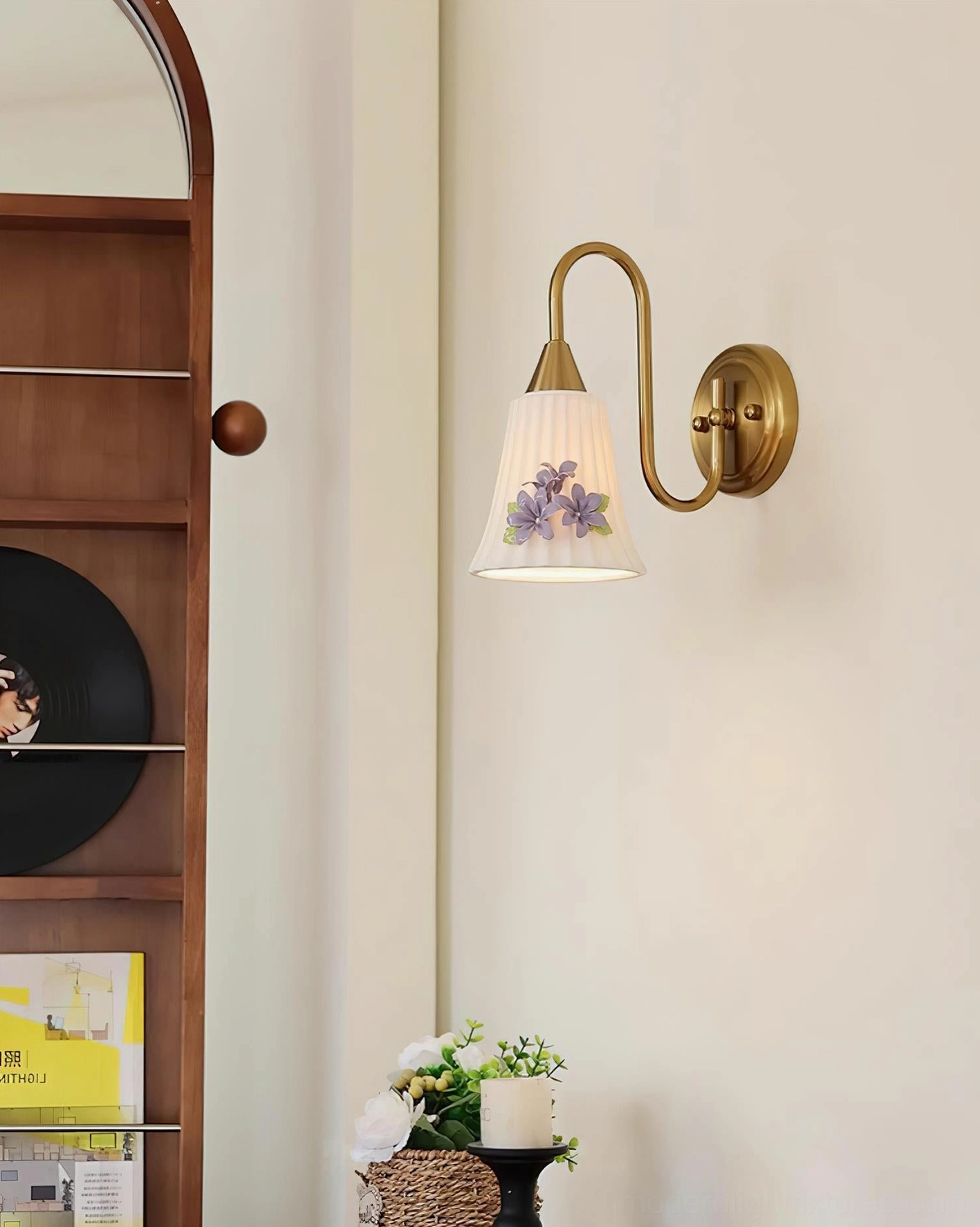 Fiorenta wall sconce right side view in home entryway with brass curved arm and small purple flower ornament