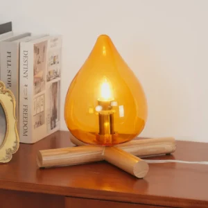 Firebeam modern table lamp three-quarter side view on wooden side table with books and home decor