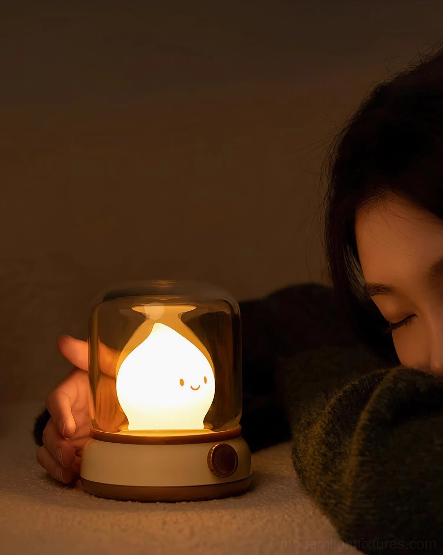 Flame LED night light on bedroom bed, warm candlelight ambiance, person resting beside glowing lamp