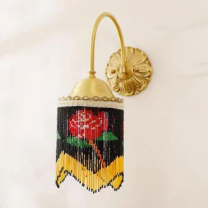 Black beaded wall lamp with brass curved arm and rose pattern close-up showing hand-strung bead details