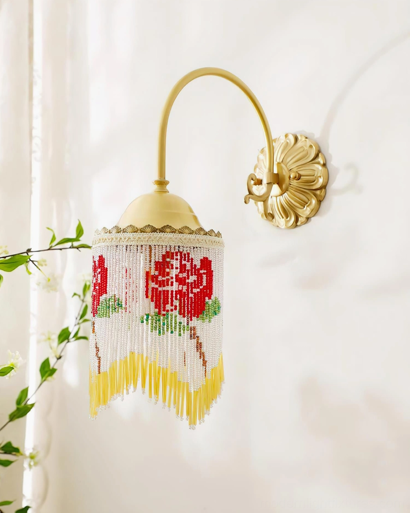 Bohemian beaded wall lamp with white beaded fringe and warm ambient lighting creating romantic shadows on wall