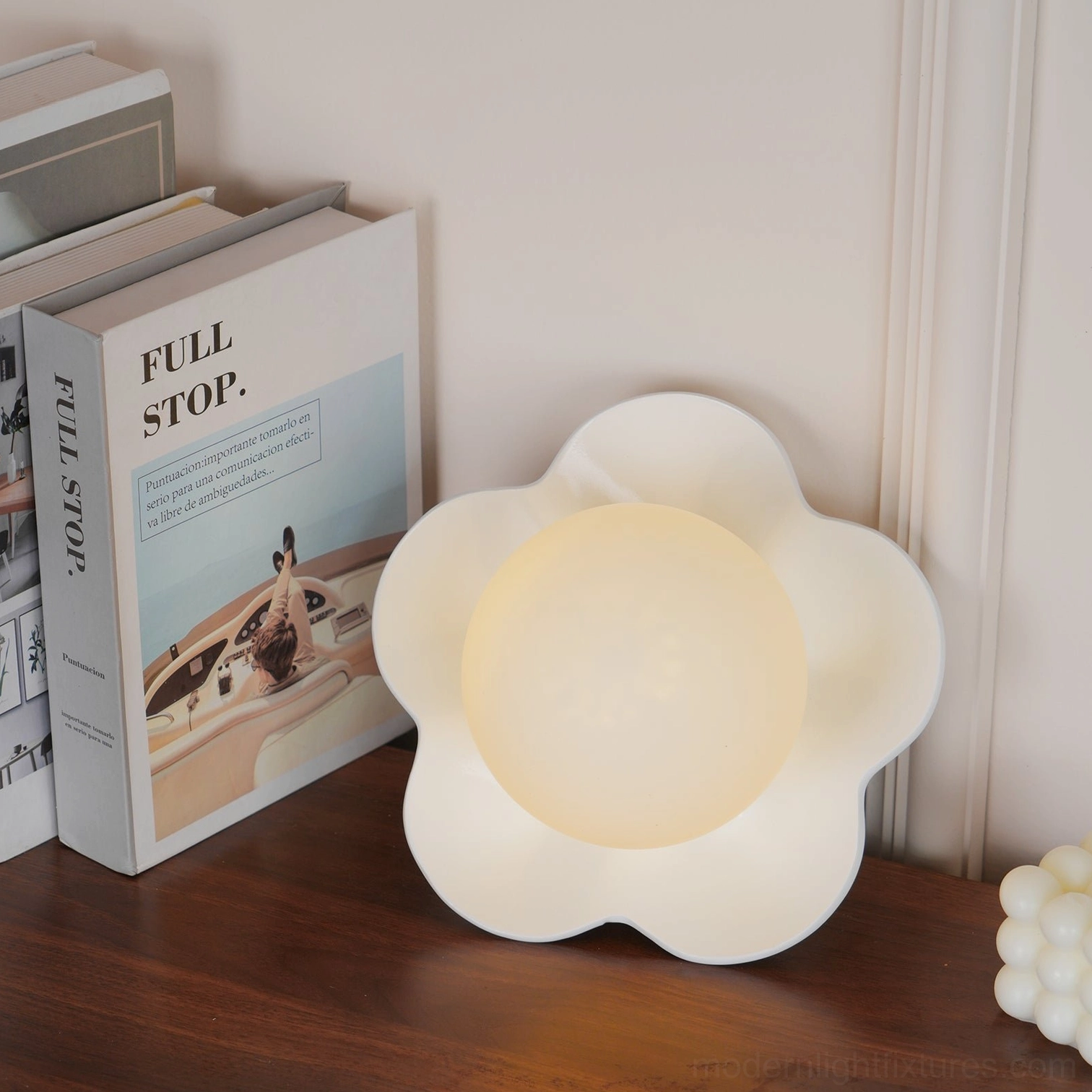 Fleur wall sconce illuminated at full brightness - sculptural resin flower lamp frosted center glowing brightly