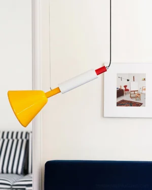 Bauhaus-inspired color-block pendant lamp hanging in contemporary living room with blue sofa and wall art