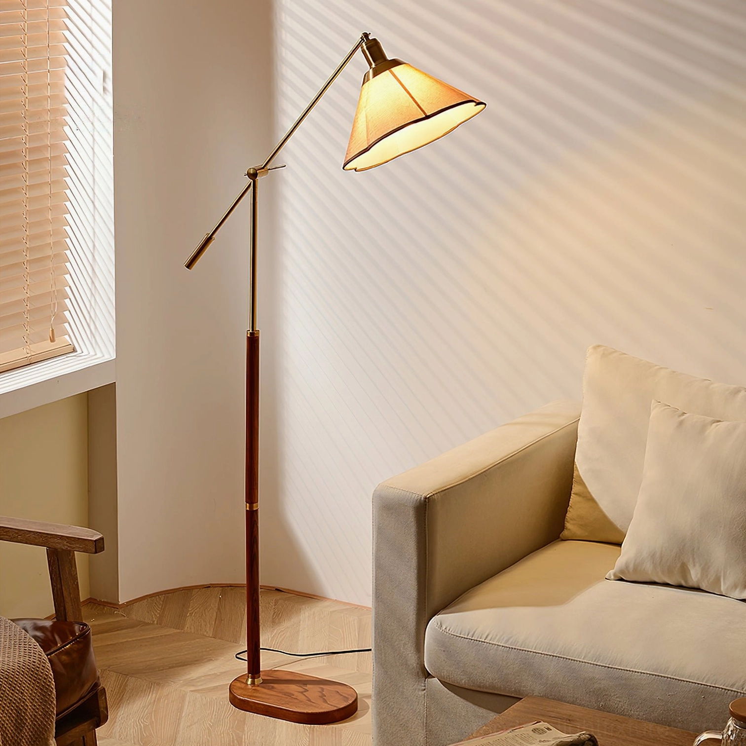 Illuminated swing arm floor lamp with warm glowing tapered fabric shade, wooden pole, and brass hardware in residential interior