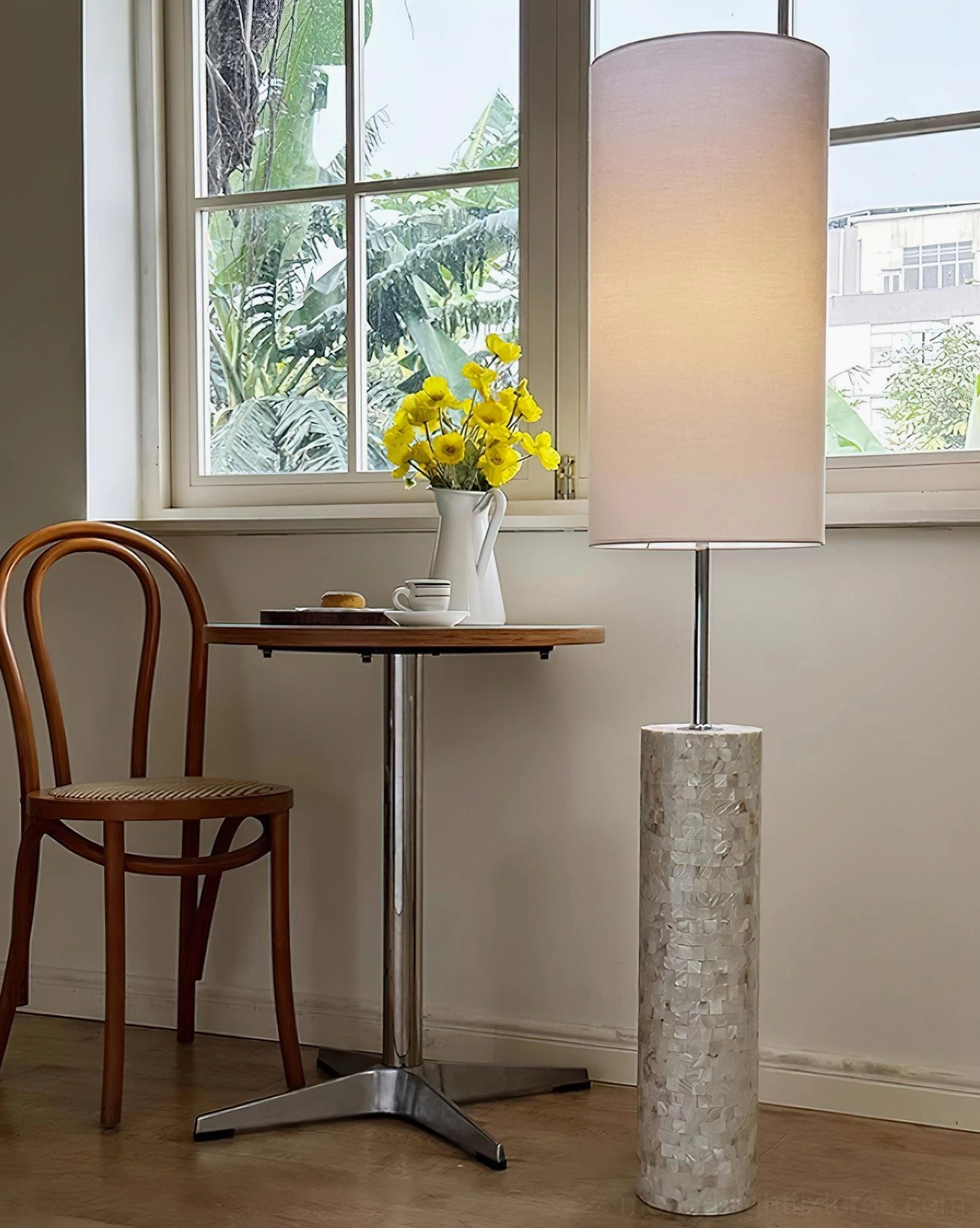 Contemporary floor lamp with soft pink fabric shade in window-side dining nook with yellow flowers