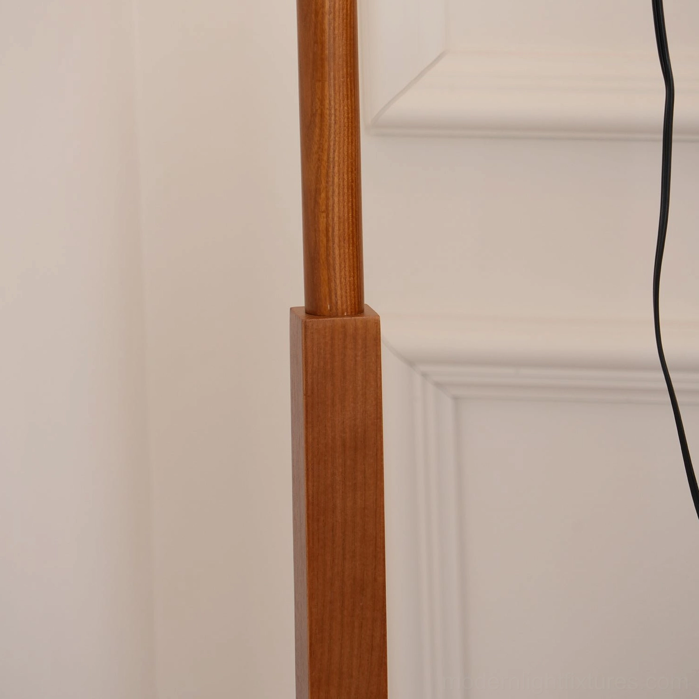Detail view of floor lamp showing fabric shade texture, wooden pole attachment, and black socket hardware