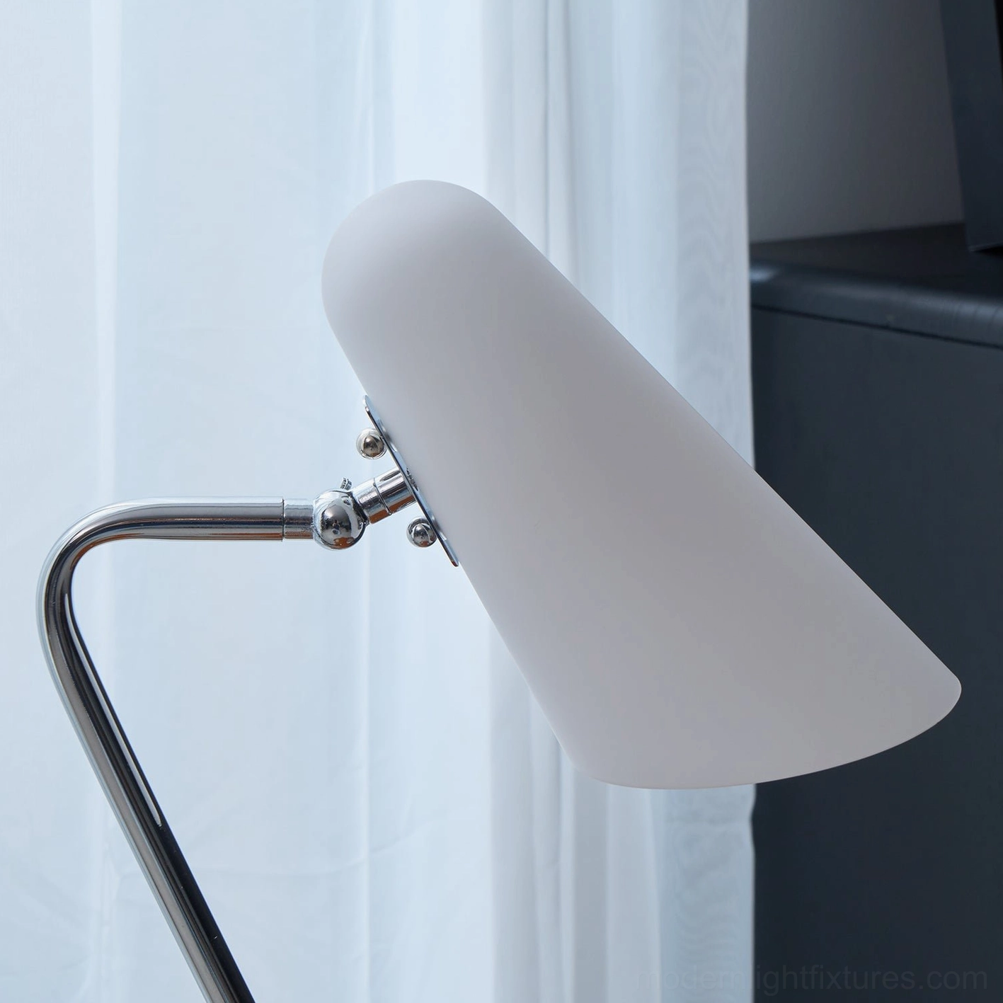 Close-up detail of white fabric opal shade and polished chrome metal joint assembly on floor lamp
